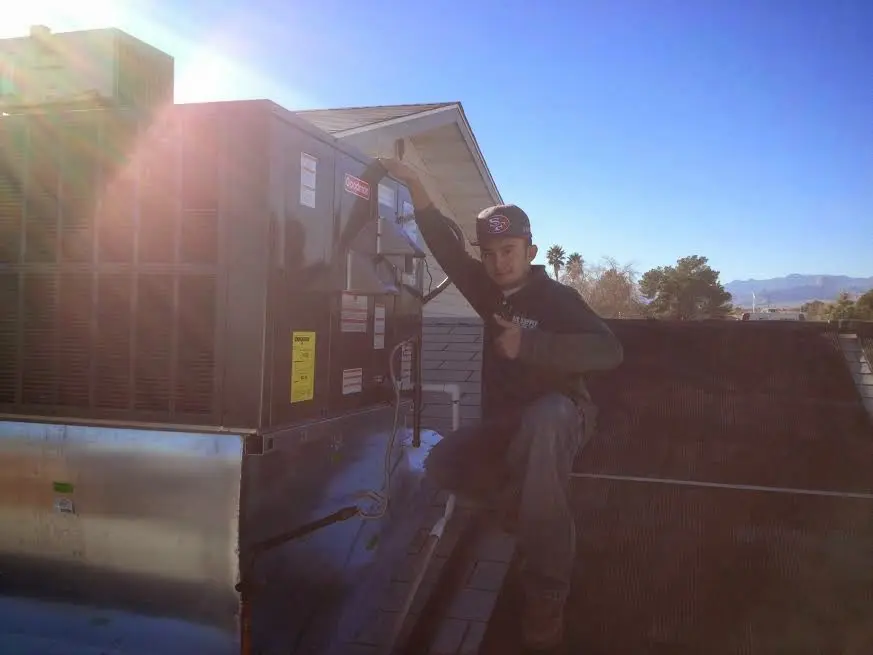 HVAC technician performing HVAC Inspection on a rooftop unit in Stansbury Park